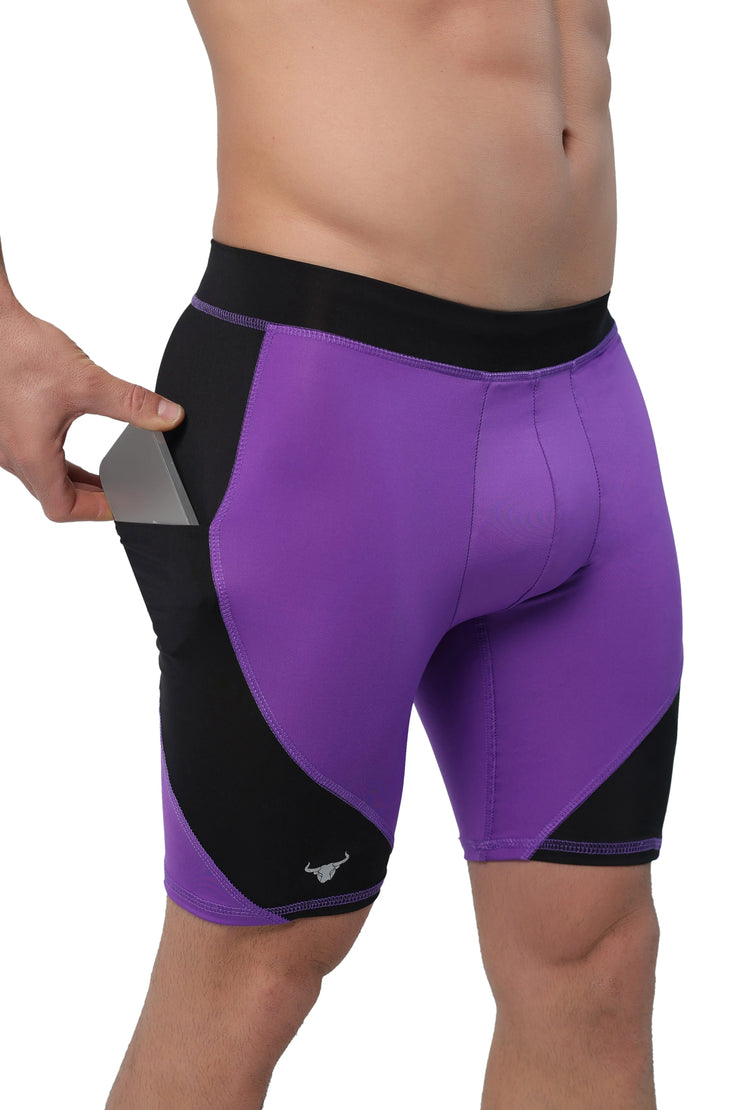 Compression shorts for men with pockets in purple and black, model placing phone inside.