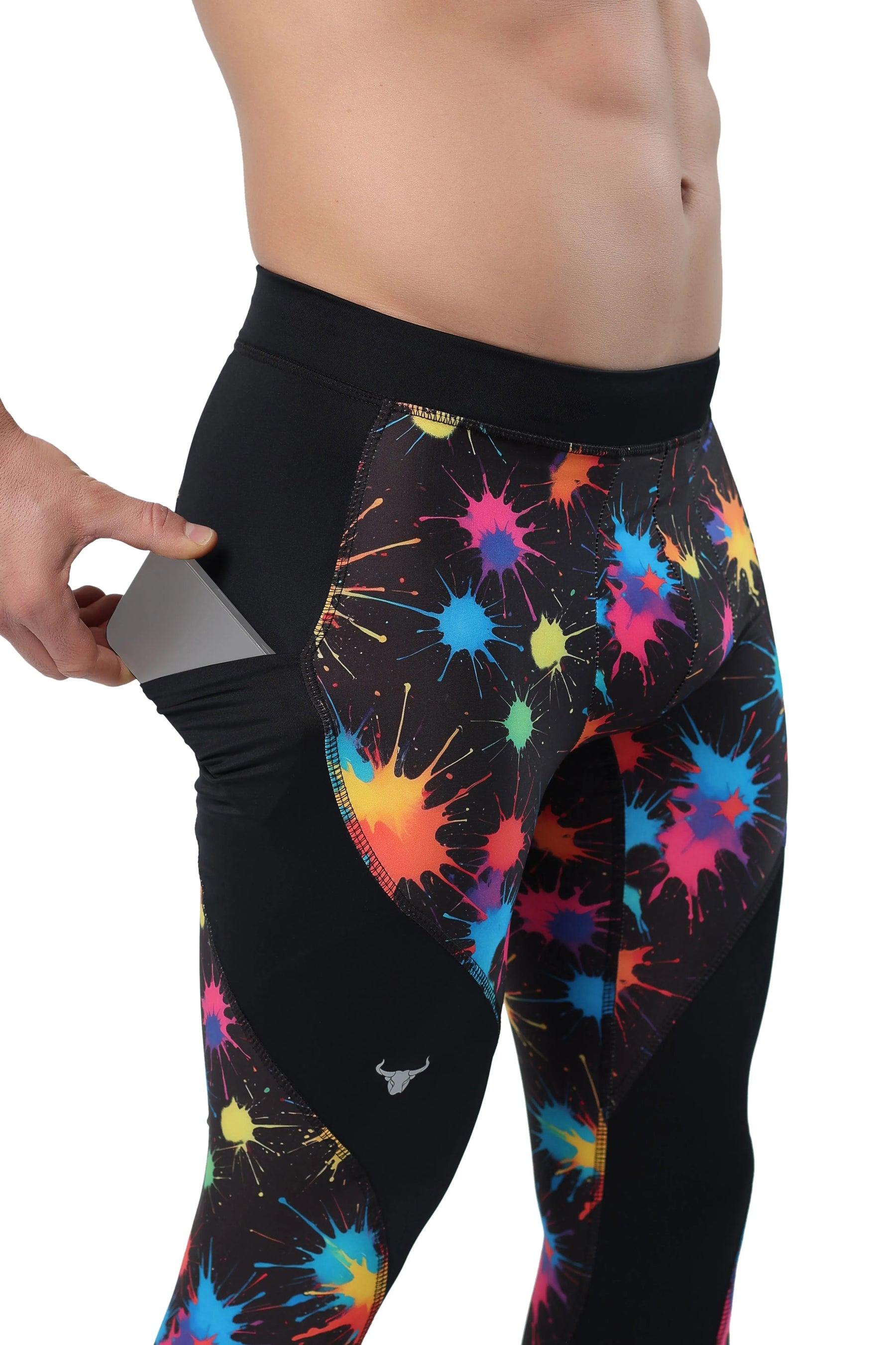 Men's leggings with pouch in black fabric featuring colorful paint splatter design and side pocket holding a smartphone.