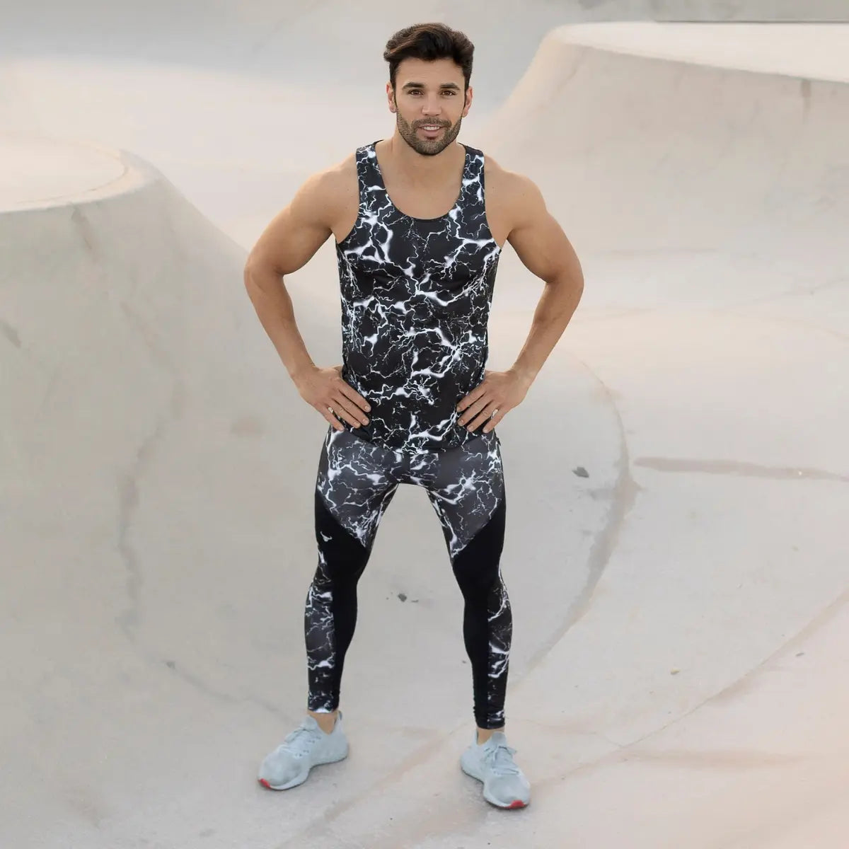 Compression wear for men shown with a model in black marble-patterned tights and tank top at a skatepark