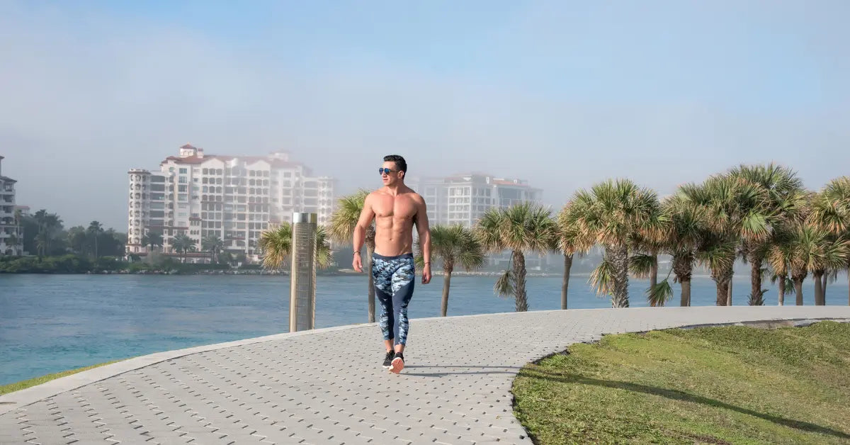 blue camo men's leggings tights modeled on a waterfront path.